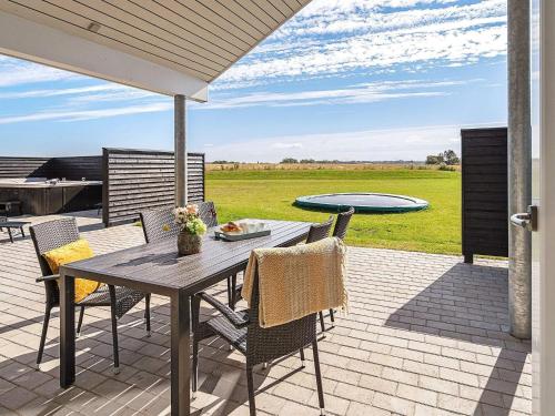 a patio with a table and chairs and a pool at Luxury Retreat for 18 - By Traum Ferienwohnungen in Spottrup
