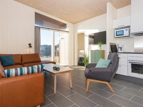 ein Wohnzimmer mit einem Sofa und einem Stuhl in der Unterkunft 6 person holiday home in Ringk bing in Ringkøbing