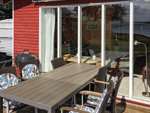 una mesa de madera y sillas en un patio en 4 person holiday home in Martofte, en Martofte