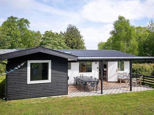 a black and white house with a patio at 6 person holiday home in Allinge in Allinge