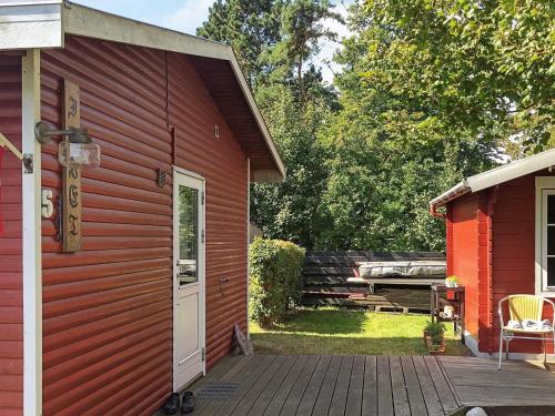 un edificio rojo con puerta y patio en 4 person holiday home in Martofte, en Martofte