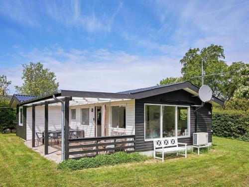 uma pequena casa com duas cadeiras no quintal em 6 person holiday home in Allinge em Allinge