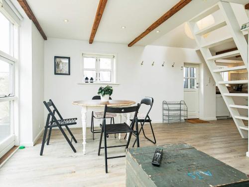 - une salle à manger avec une table, des chaises et des escaliers dans l'établissement 4 star holiday home in Skagen, à Skagen