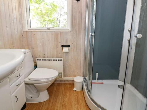 uma casa de banho com um WC, um chuveiro e um lavatório. em Holiday home Hadsund II em Hadsund