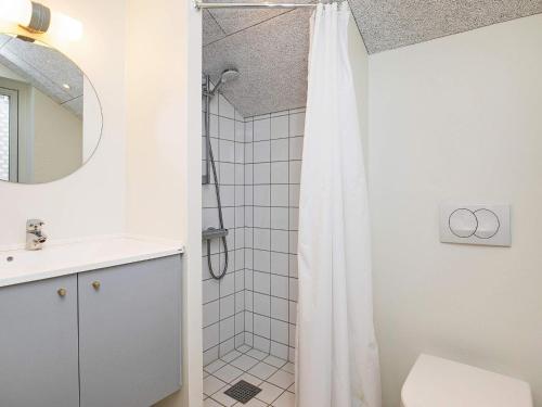 a bathroom with a shower with a white shower curtain at Holiday home Læsø VII in Læsø