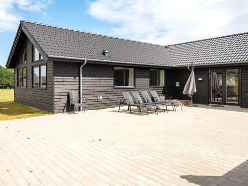 a house with chairs and a table in front of it at Luxury Beach Retreat - By Traum Ferienwohnungen in Sarup