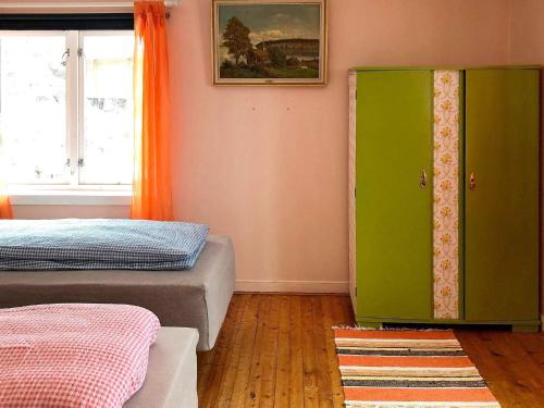 - une chambre avec 2 lits et une armoire verte dans l'établissement Holiday home STONGLANDSEIDET II, à Stonglandseidet