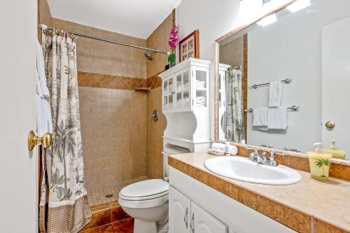 a bathroom with a sink and a toilet and a mirror at Kihei Bay Surf 236 in Kihei