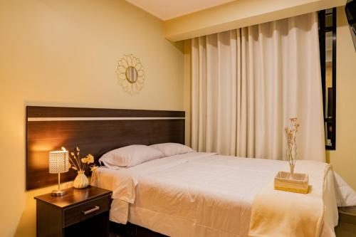 Un dormitorio con una gran cama blanca y una mesa en Santa Lucía Suite Hotel, en Chachapoyas