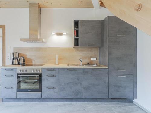 a kitchen with gray cabinets and a sink at Tobias Top 2 in Bramberg am Wildkogel