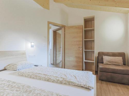 een slaapkamer met een bed en een stoel bij Tobias Top 2 in Bramberg am Wildkogel