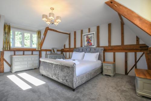 a bedroom with a large bed and a staircase at Moat Barn in Debach