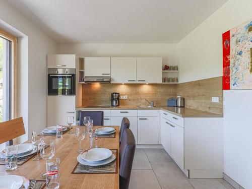 a kitchen with a wooden table with plates and wine glasses at Haus Rabl Hansi in Itter