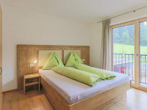 una camera da letto con un letto con cuscini verdi e una finestra di Ferienhaus Rabl a Itter