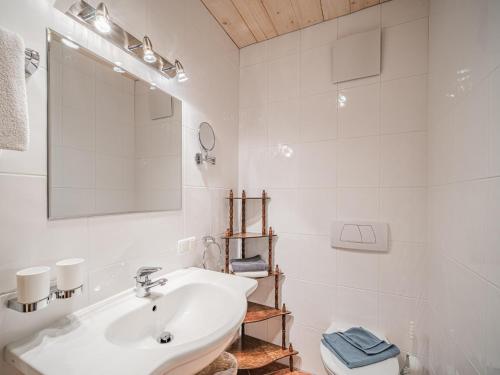 Baño blanco con lavabo y espejo en Weberhof Top 5, en Brixen im Thale