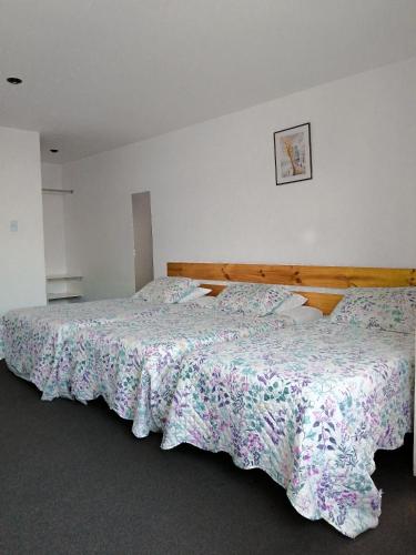a bedroom with two beds and a picture on the wall at Hotel La Posada Del Ingles in Chiclayo