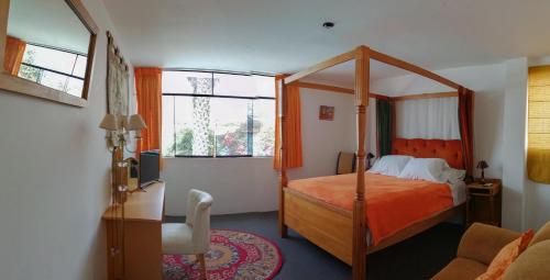 - une chambre avec un lit à baldaquin et 2 fenêtres dans l'établissement Hotel La Posada Del Ingles, à Chiclayo