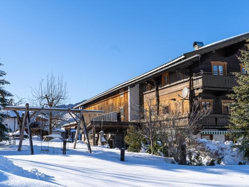 a large wooden house in the snow with snow covered ground at Weberhof Top 3-4-5 in Brixen im Thale
