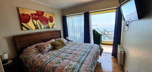 1 dormitorio con cama y ventana grande en Hermoso Departamento Frente al Muelle Vergara - Viña del Mar, en Viña del Mar
