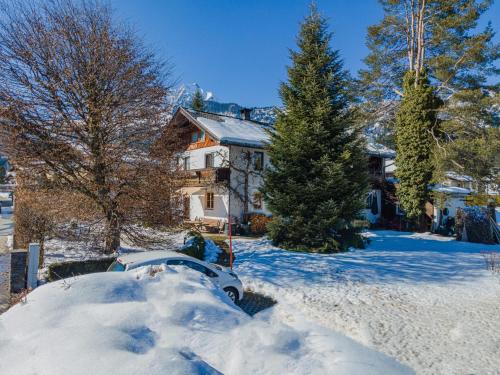a car covered in snow in front of a house at Haus Jöchl Top 1 in Rettenbach