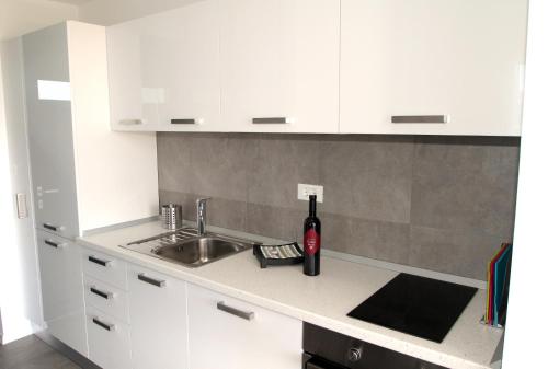 a kitchen with a sink and a bottle of wine on a counter at Villa Lavanda Deluxe in Rogoznica