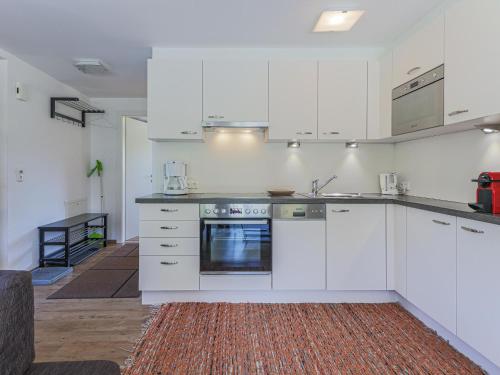 a kitchen with white cabinets and a stove top oven at Haus Jöchl Top 2 in Rettenbach