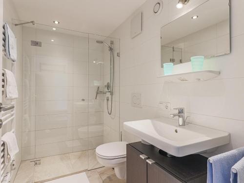 a white bathroom with a sink and a shower at Chalet Jöchl in Sankt Johann in Tirol