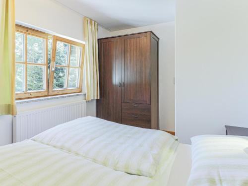 een slaapkamer met 2 bedden en een houten kast bij Chalet Jöchl in Sankt Johann in Tirol