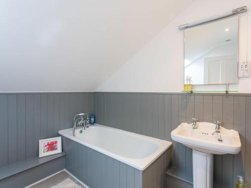 ein Badezimmer mit einer Badewanne, einem Waschbecken und einem Spiegel in der Unterkunft The Bothy in Boltby