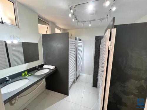 baño con 2 lavabos y espejo grande en Hostel do Lago, en São José do Rio Preto