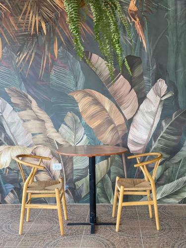 a table and two chairs in front of a mural at Santa Lucía Suite Hotel in Chachapoyas