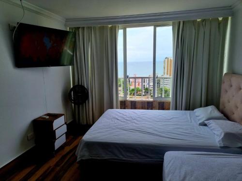 Habitación de hotel con cama y ventana grande en "LOW COST" Conquistador-Laguito, en Cartagena de Indias