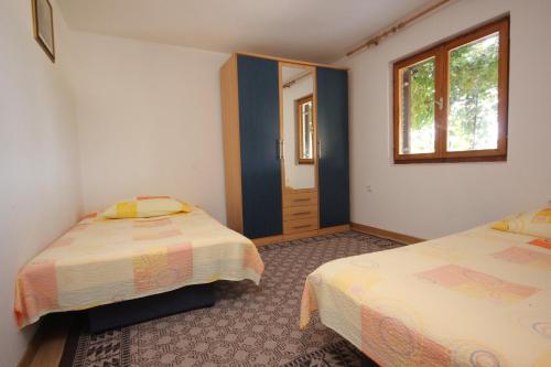 - une chambre avec 2 lits et une fenêtre dans l'établissement Apartment Vis 8448c, à Vis