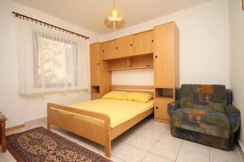 1 dormitorio con 1 cama, armario y silla en Apartments by the sea Okrug Gornji, Ciovo - 8663 en Trogir
