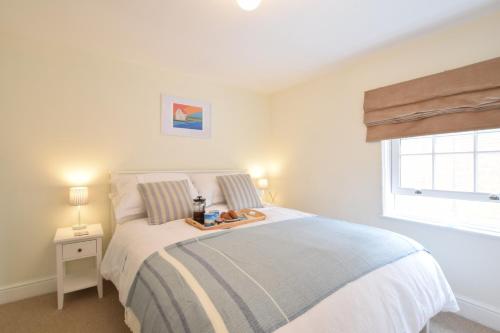 una camera da letto con un letto e un vassoio di cibo sopra di 1 Tailors Cottage, Woodbridge a Woodbridge