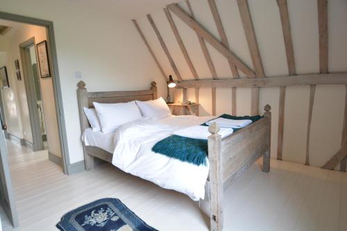 a bedroom with a bed with white sheets and pillows at The Gig House, Stowupland in Stowmarket