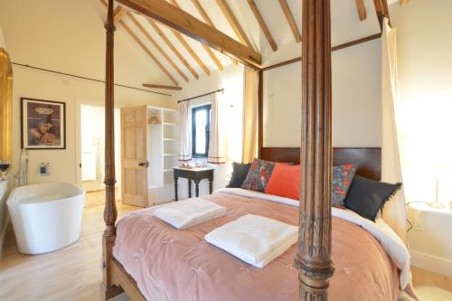 a bedroom with a bed with a bath tub and a tub at Fishpond House, Sotherton in Sotherton