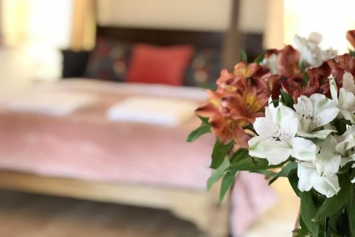 a vase of flowers with a couch in the background at Fishpond House, Sotherton in Sotherton