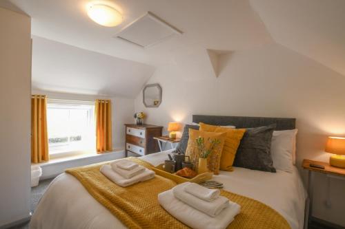 a bedroom with a bed with two towels on it at Pink Cottage, Stradbroke in Stradbroke