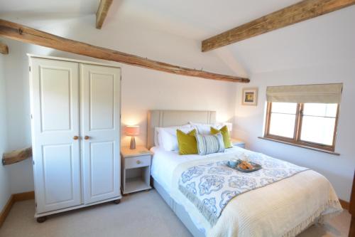 a bedroom with a bed and a window at May Barn, Ixworth in Ixworth