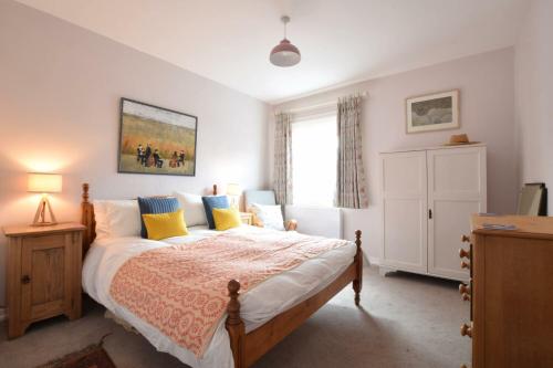 a bedroom with a bed with yellow and blue pillows at Seaflower, Aldeburgh in Aldeburgh