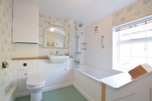 a bathroom with a toilet and a sink and a window at Seaflower, Aldeburgh in Aldeburgh