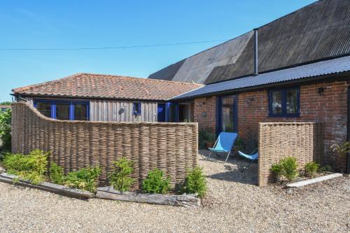 a brick house with a fence in front of it at Onna's Stable, Sotherton in Sotherton