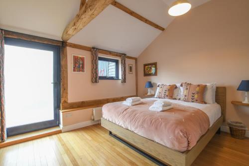 a bedroom with a large bed and a large window at Onna's Stable, Sotherton in Sotherton