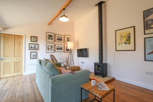 a living room with a couch and a wood stove at Onna's Stable, Sotherton in Sotherton