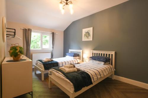 2 camas individuais num quarto com uma janela em The Piglets em Woodbridge