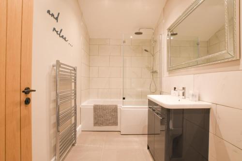 a bathroom with a sink and a bath tub at The Piglets in Woodbridge