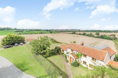 an aerial view of a house with a field at Skelder, Parham in Parham