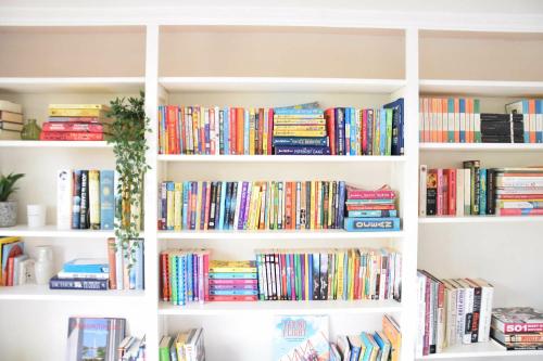 a white book shelf filled with lots of books at Skelder, Parham in Parham