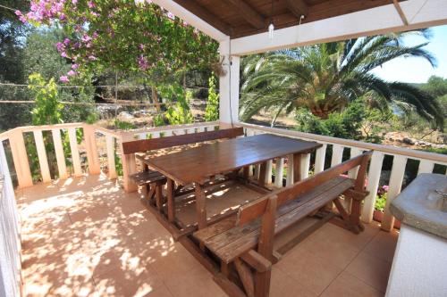 - un banc en bois sur une terrasse couverte avec une table dans l'établissement Secluded fisherman's cottage Krknata, Dugi otok - 397, à Žman